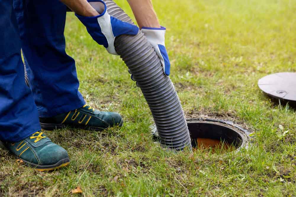 plumber lowering the suction hose into the septic tank Acworth, GA