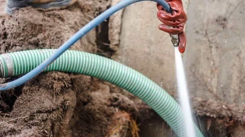 Septic tank cleaning after draining to maintain system.